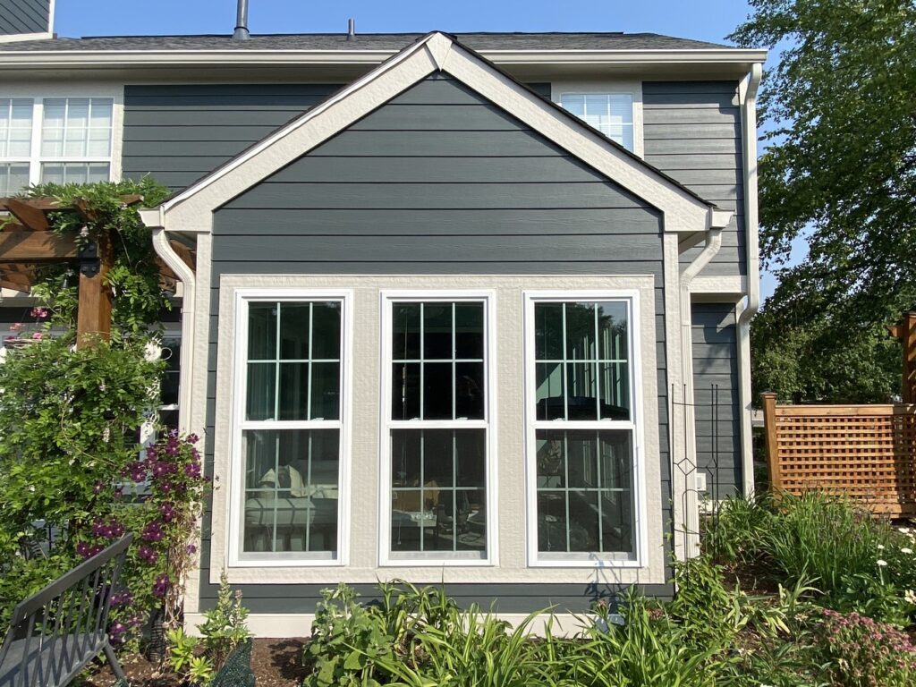 Windows of a gray home replaced by Marvin Windows installers at Strenova Exteriors