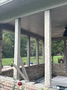 A screened in porch with the screens being removed.