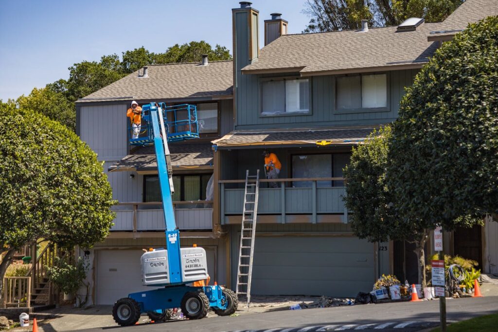 Contractors repairing a home’s exterior