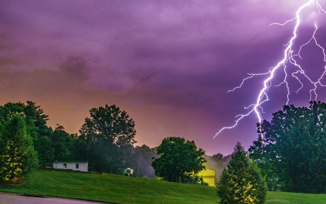 Lightning strike above homes and trees